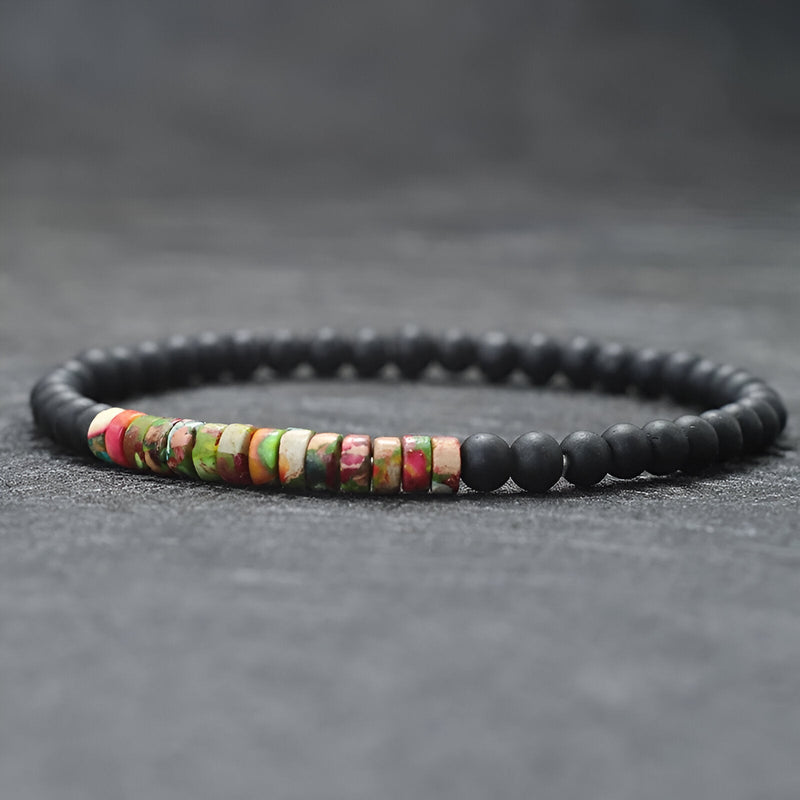 Bracelet fin pour homme en perles noires mates avec pierres naturelles multicolores centrées.