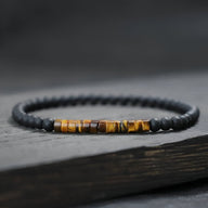Bracelet fin pour homme en perles noires mates avec pierres naturelles œil de tigre brunes lustrées.