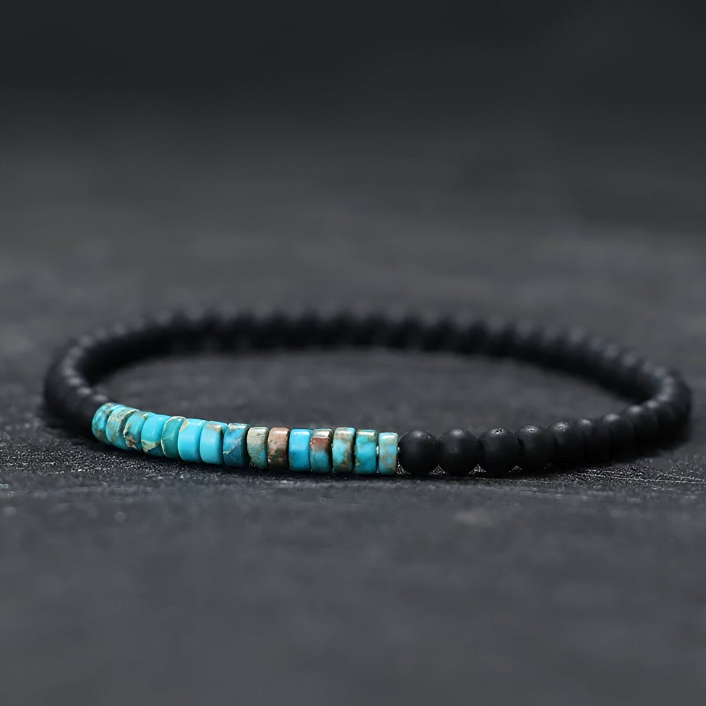 Bracelet fin pour homme en pierres naturelles noires et turquoises sur fil élastique.
