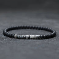 Bracelet fin pour homme en perles noires mat et pierres grises naturelles centrales.