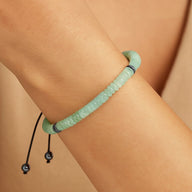 Bracelet ajustable en pierres naturelles aventurine, perles cylindriques et rondes vert clair sur cordon noir.