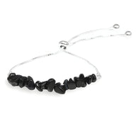 Bracelet pour femme en pierres naturelles noires irrégulières avec chaîne argentée ajustable.