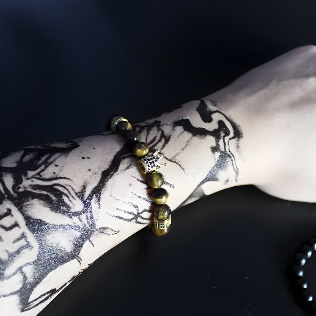 Bracelet homme en oeil de tigre vert avec perle centrale dorée et détails gravés.