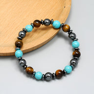 Bracelet mixte perles œil de tigre marron, turquoise bleue et hématite grise sur fil élastique.