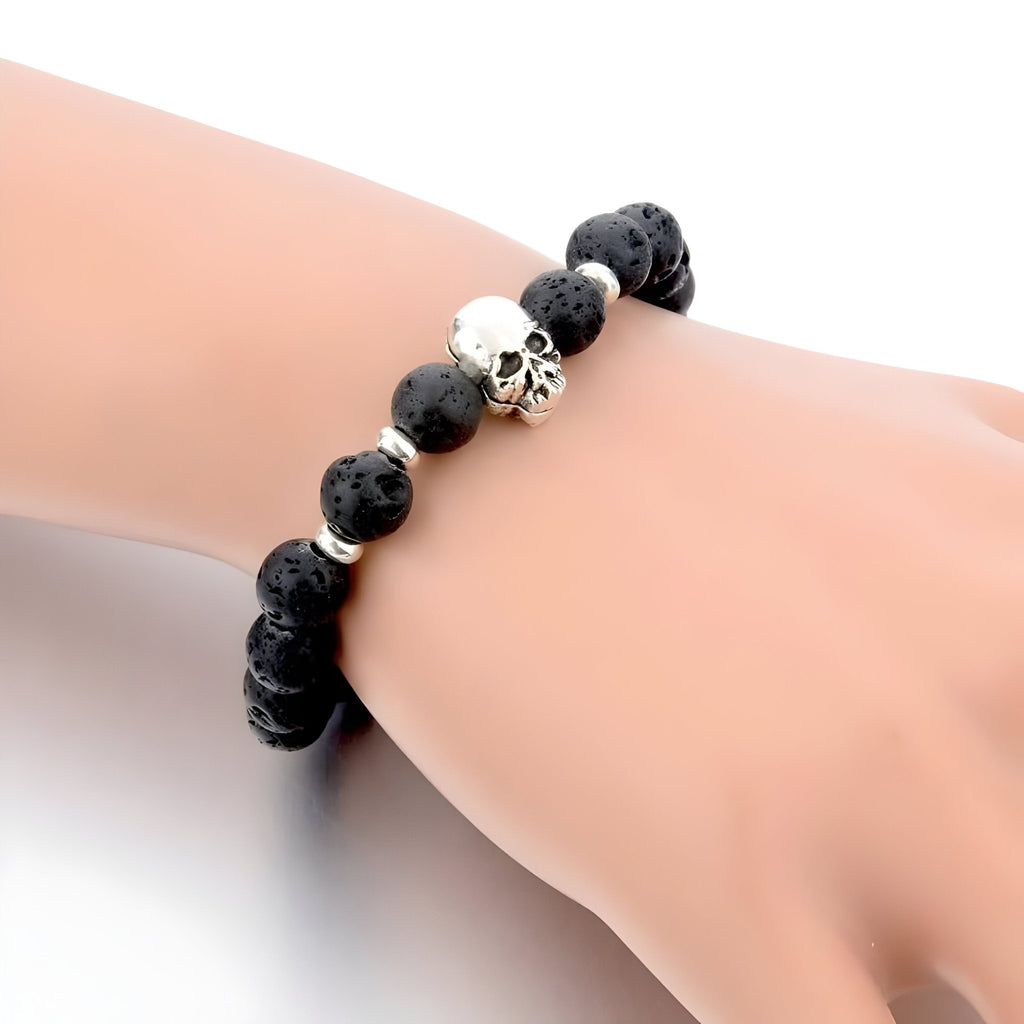 Bracelet homme perles noires en pierre volcanique avec tête de mort argentée centrale.