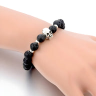 Bracelet homme perles noires en pierre volcanique avec tête de mort argentée centrale.