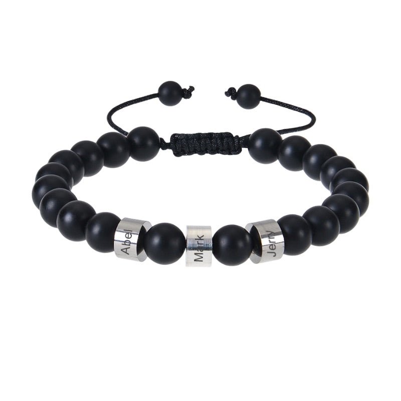 Bracelet Valen en pierres naturelles onyx noires avec trois plaques métalliques gravées et cordon ajustable noir.