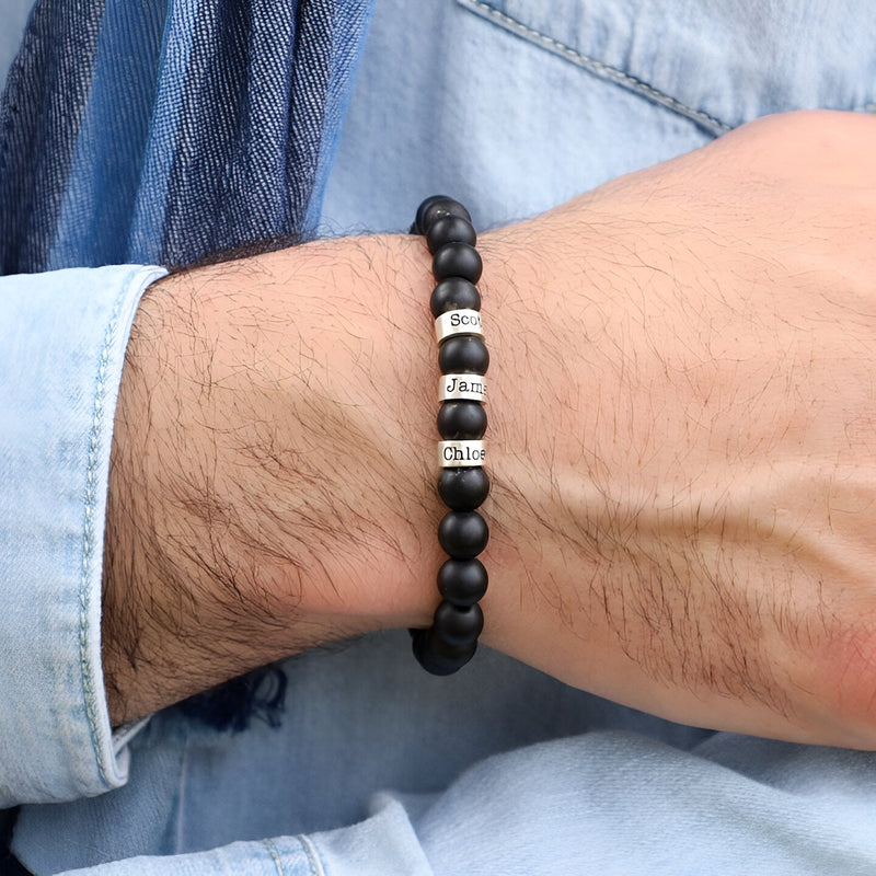 Bracelet homme en onyx noir mat avec trois plaques argentées gravées, style épuré.