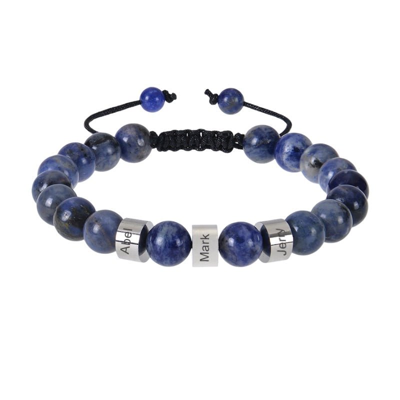 Bracelet en pierres naturelles bleues sodalite avec plaques métalliques personnalisées et cordon noir ajustable.