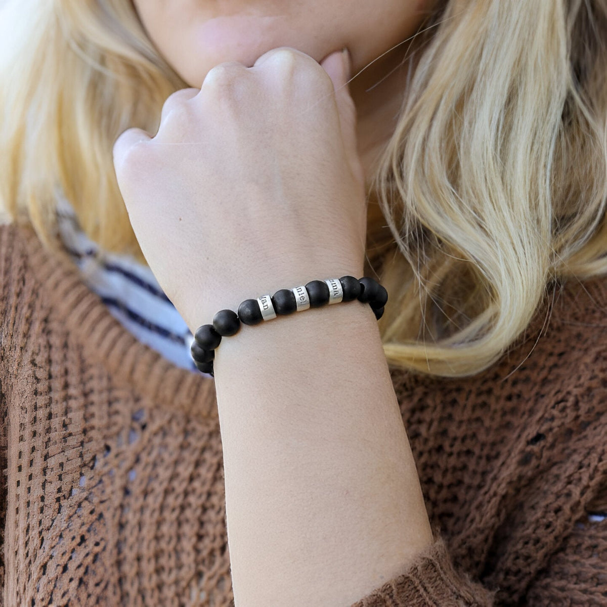 Bracelet Valen en pierres naturelles onyx noires avec trois plaques métalliques argentées portées au poignet.