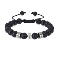 Bracelet en pierres volcaniques noires avec trois plaques argentées gravées et fermeture coulissante noire.