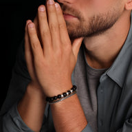 Bracelet masculin triple plaques en onyx noir et argent sur poignet peau claire.