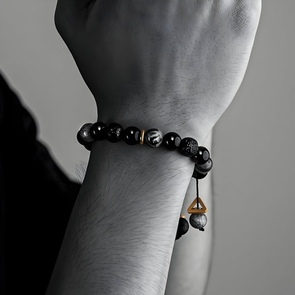 Bracelet pour homme en pierres naturelles noires volcaniques avec perles lisses et finition pendentif en métal doré.