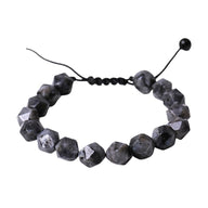 Bracelet en pierres naturelles taillées gris foncé avec cordon ajustable noir et perle de serrage.
