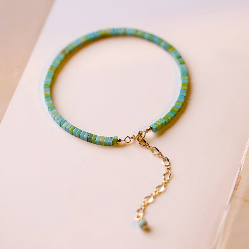 Bracelet femme en pierres turquoises et vertes avec chaînette dorée ajustable.