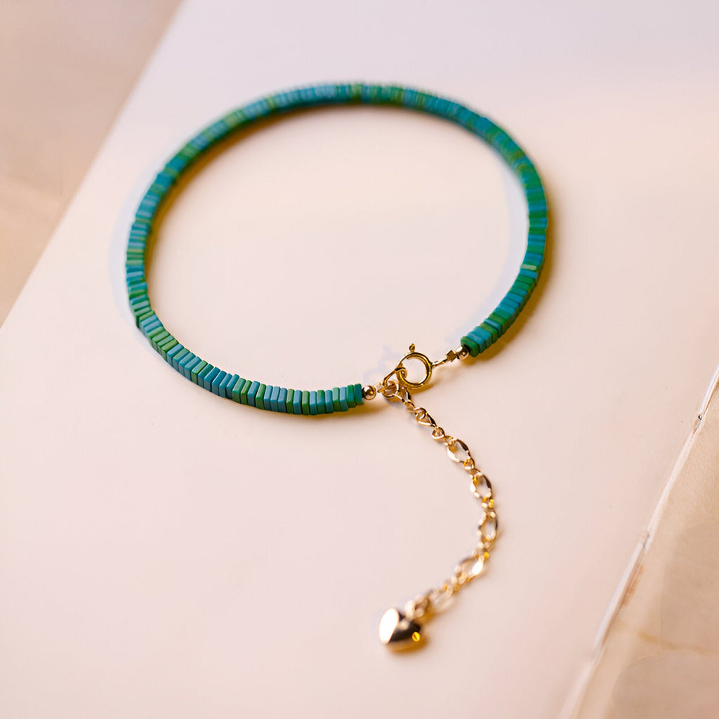 Bracelet femme en pierres turquoise bleue et verte avec fermoir et chaîne ajustable dorés.
