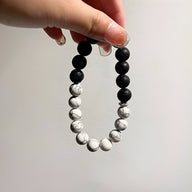 Bracelet mixte en pierres volcaniques rondes noires et blanches alternées, style bi-colore.