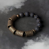 Bracelet femme en pierres volcaniques noires et gros éléments en laiton martelé au style ancien.