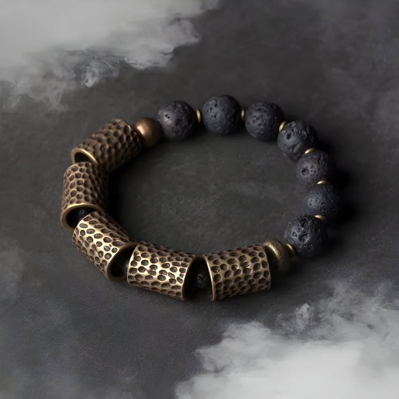 Bracelet femme en pierres volcaniques noires et gros éléments en laiton martelé au style ancien.