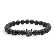 Bracelet homme en pierres volcaniques noires avec œil de tigre bleu et tête de loup argentée centrale.