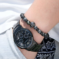 Bracelet homme en pierres volcaniques grises avec perles d'œil de tigre gris et tête de loup en métal noir mat.