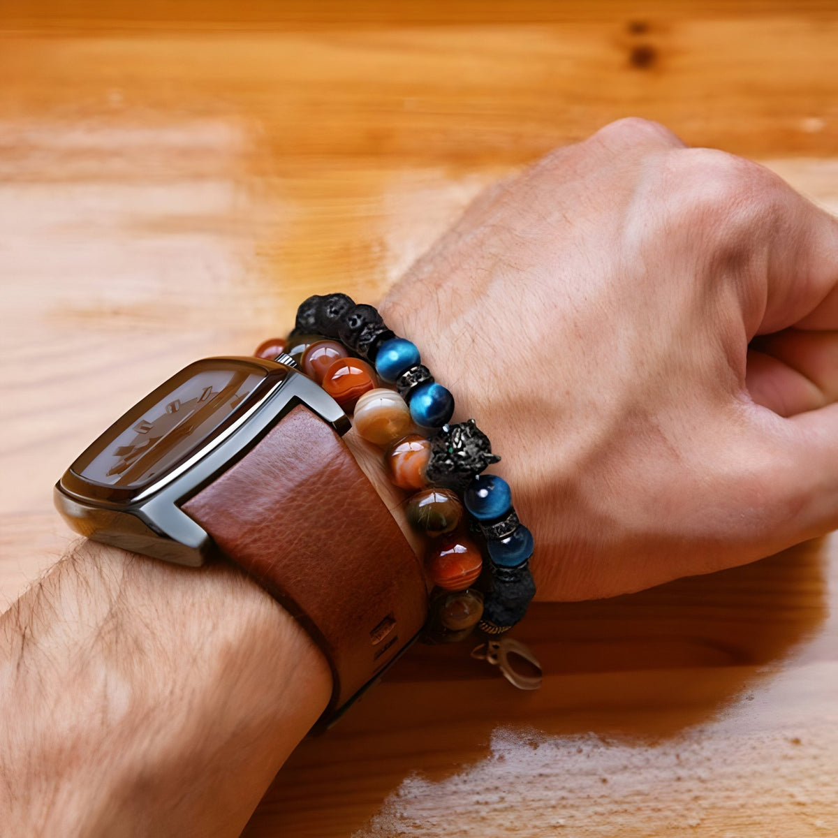 Bracelet homme en pierres volcaniques noires, perles œil de tigre bleu et tête de loup argentée.