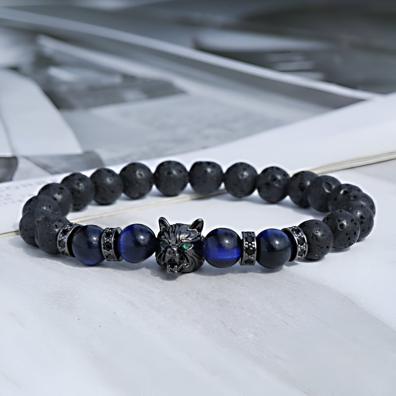 Bracelet masculin en pierres volcaniques noires et perles œil de tigre bleu avec tête de loup métallique détaillée.
