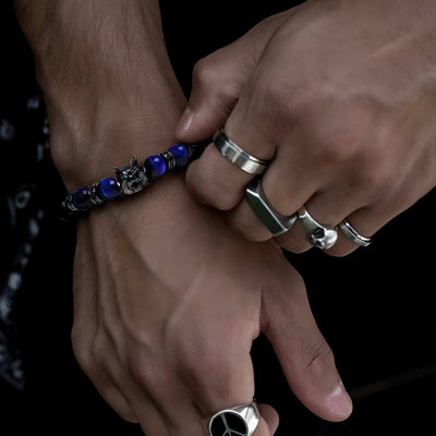 Bracelet homme en pierres volcaniques et perles œil de tigre bleu avec tête de loup argentée sculptée.