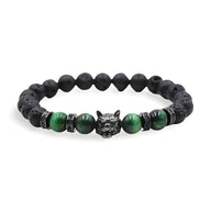Bracelet homme en pierres volcaniques noires et oeil de tigre vert, tête de loup argentée au centre.