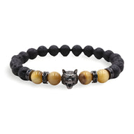 Bracelet homme en pierres volcaniques noires et perles œil de tigre jaunes avec tête de loup en métal gris.