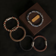 Set de quatre bracelets en polyester tressé, motifs colorés variés, fermoirs magnétiques métalliques, style unisexe.