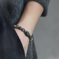 Bracelet mixte en perles de quartz noir et bois d’ébène avec pendentif doré, style élégant et naturel.