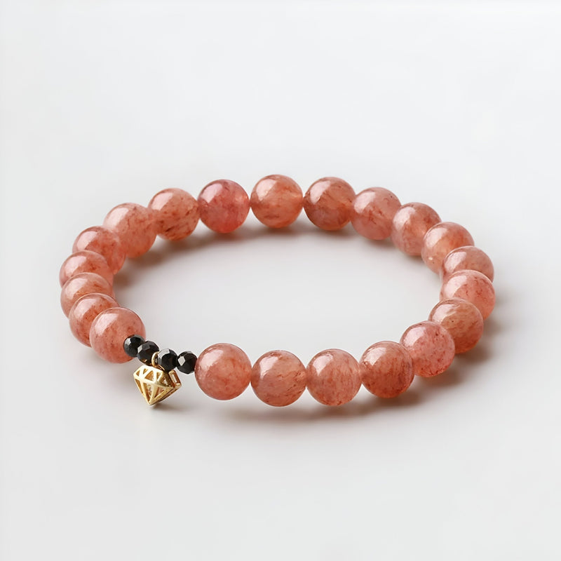 Bracelet femme perles rondes quartz rose avec pendentif cœur doré et perle noire.