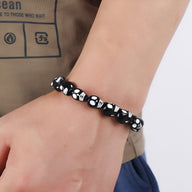 Bracelet pour homme avec crânes en résine noire et blanche, style assemblé et moderne.