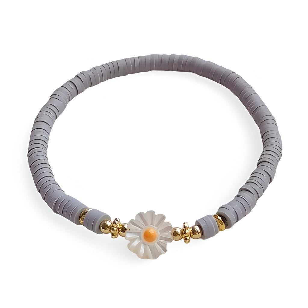 Bracelet en résine gris orné d'une marguerite blanche avec cœur jaune et perles dorées.