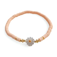 Bracelet fin en résine beige avec fleur marguerite blanche centrale et perles dorées délicates.