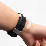 Bracelet silicone noir avec détails or pour Apple Watch, bracelet ajustable perforé style sport.