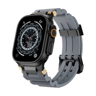 Bracelet Apple Watch gris en silicone technique avec détails or et boucle noire ajustable.