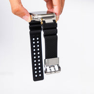 Bracelet en silicone noir avec boucle argentée et détail or pour Apple Watch, modèle Wagner ajustable.