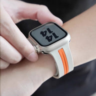 Bracelet silicone blanc avec bande orange, style technique, pour Apple Watch ajustable.