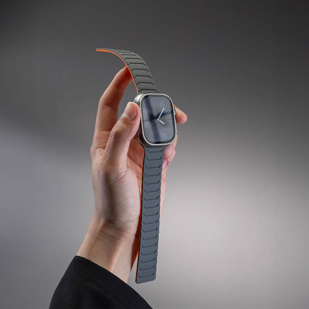 Bracelet en silicone magnétique gris foncé et orange pour Apple Watch, design ajustable et résistant.