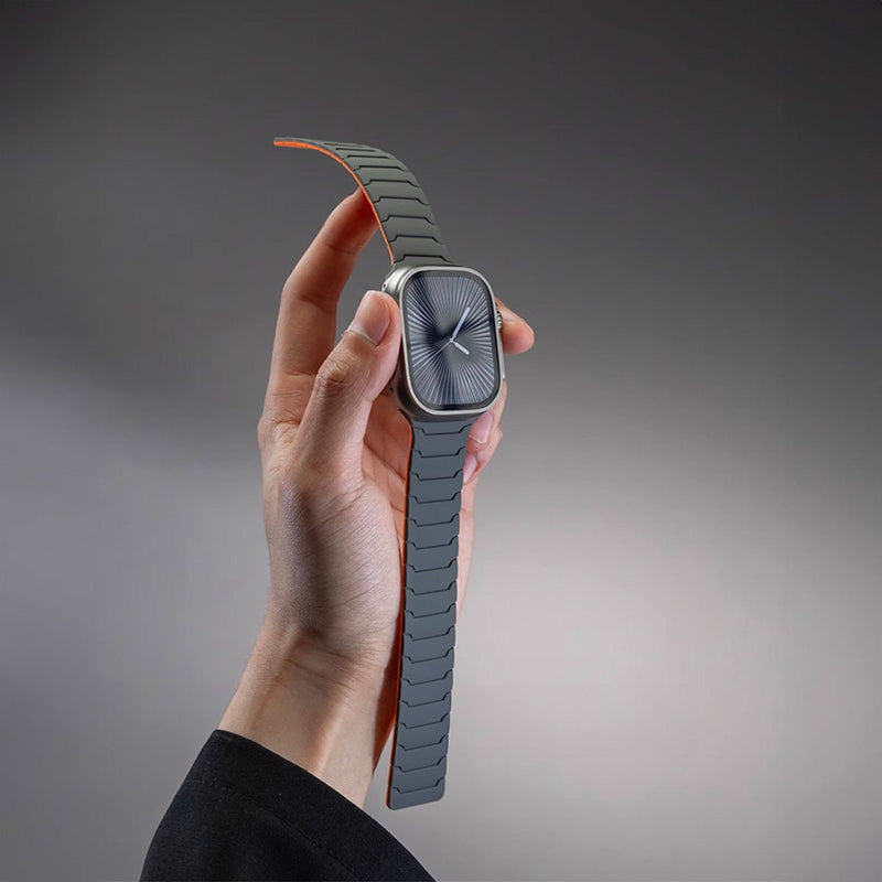 Bracelet en silicone magnétique gris foncé et orange pour Apple Watch, design ajustable et résistant.