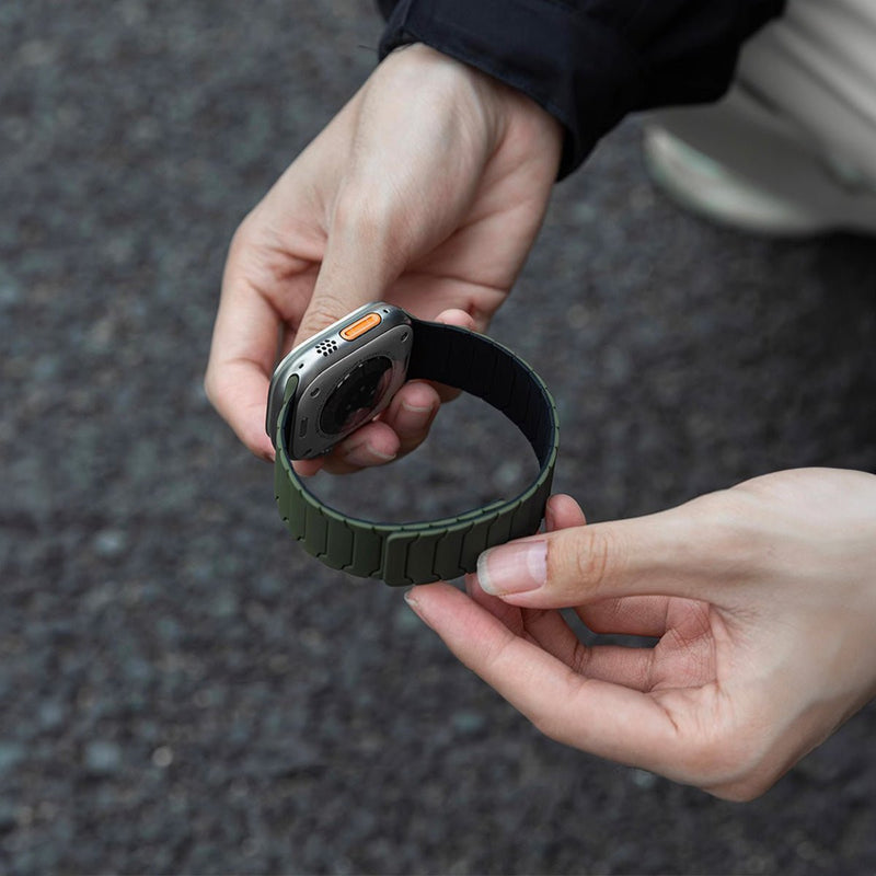 Bracelet silicone magnétique noir et orange, ajustable, pour Apple Watch, style sportif et résistant.