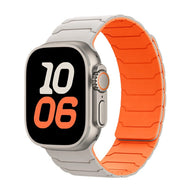 Bracelet en silicone gris clair avec intérieur orange pour Apple Watch, design magnétique ajustable.