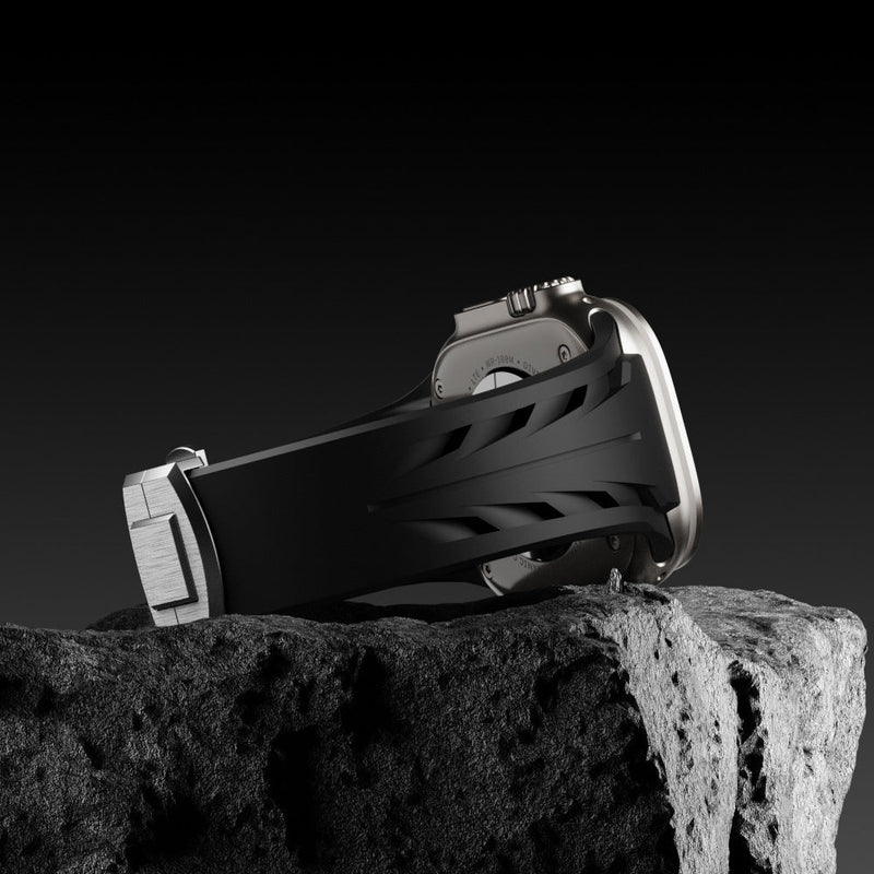 Bracelet en silicone noir texturé avec fermoir papillon argenté pour Apple Watch.