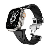 Bracelet silicone noir ajustable avec fermeture papillon argentée pour Apple Watch.