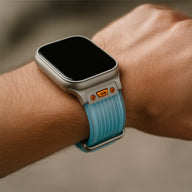 Bracelet en silicone bleu et noir pour Apple Watch, design ajouré avec détails orange, ajustable et résistant.