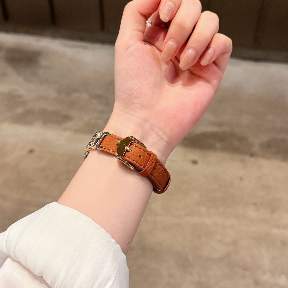 Bracelet simili cuir vegan marron avec doublure dorée et fermeture boucle en métal brillant.