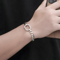 Bracelet en titane bi-colore argent et noir avec chaîne et fermoir octogonal sur poignet masculin.