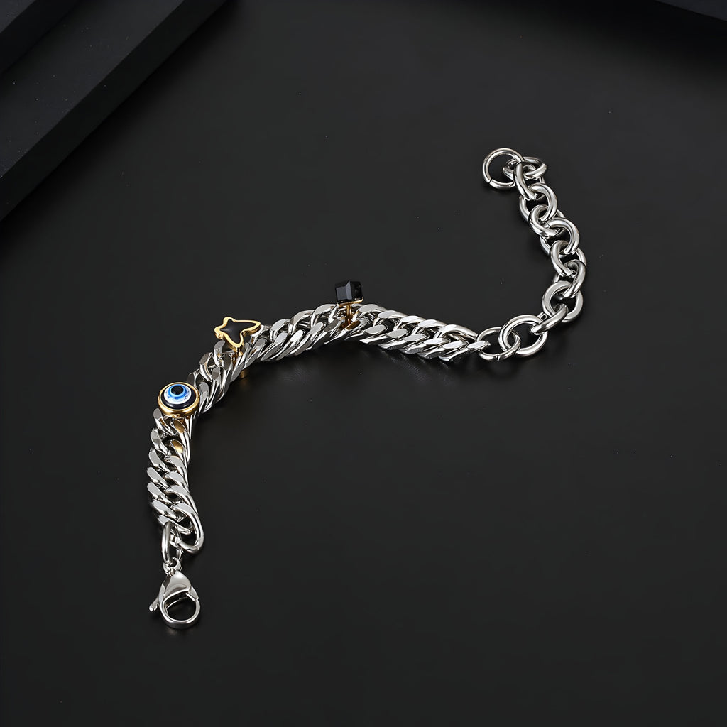 Bracelet en titane argenté à maillons larges avec charms oeil bleu et papillon doré, fermoir robuste.